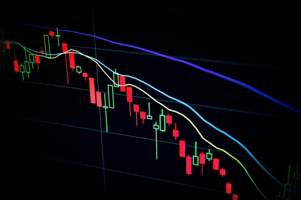 A close-up view of a candlestick chart displaying fluctuating stock prices on a dark background.